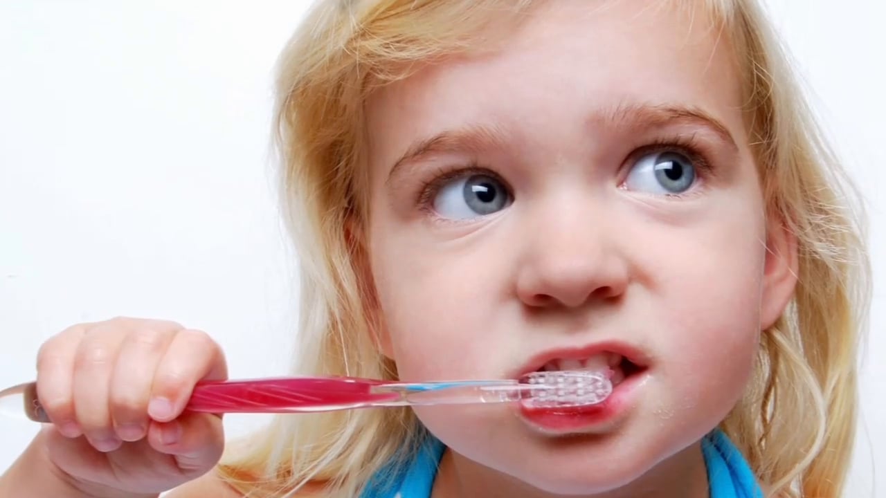 A cute baby girl brushing her teeth