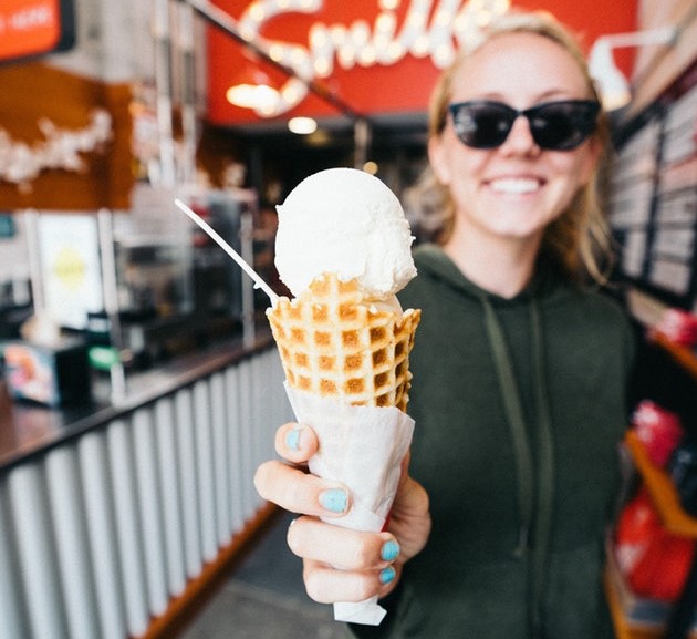A happy woman holding a vanilla ice cream