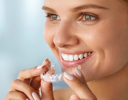 A smiling woman wearing an Invisalign