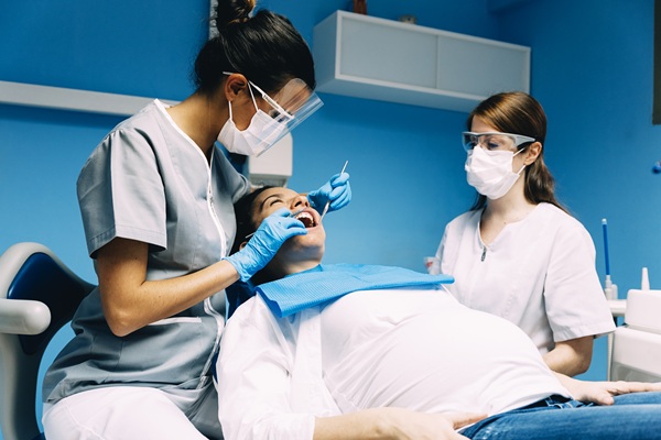 Dentists with a pregnant patient during a dental intervention.