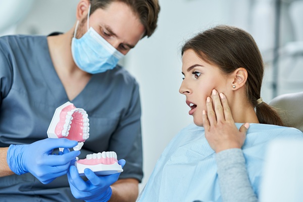 Male dentist showing gum boil to a woman patient