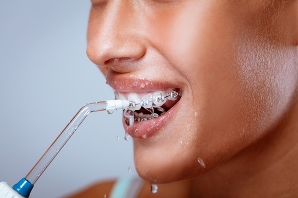 a woman using water flosser