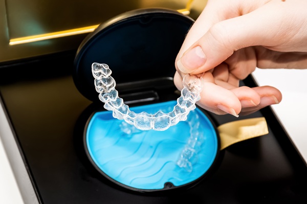 Transparent teeth aligners in a box. Invisible braces. Clear teeth straighteners. Clear plastic bracers