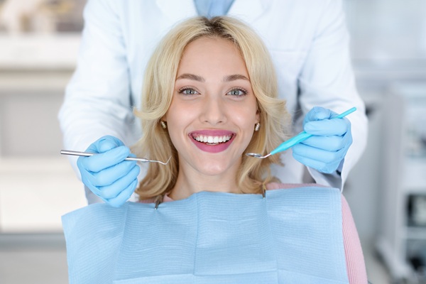 Portrait of smiling female patient pretty blonde woman attending dental clinic, having regular checkup, closeup. Cheerful young lady sitting at dental chair, showing her beautiful smile